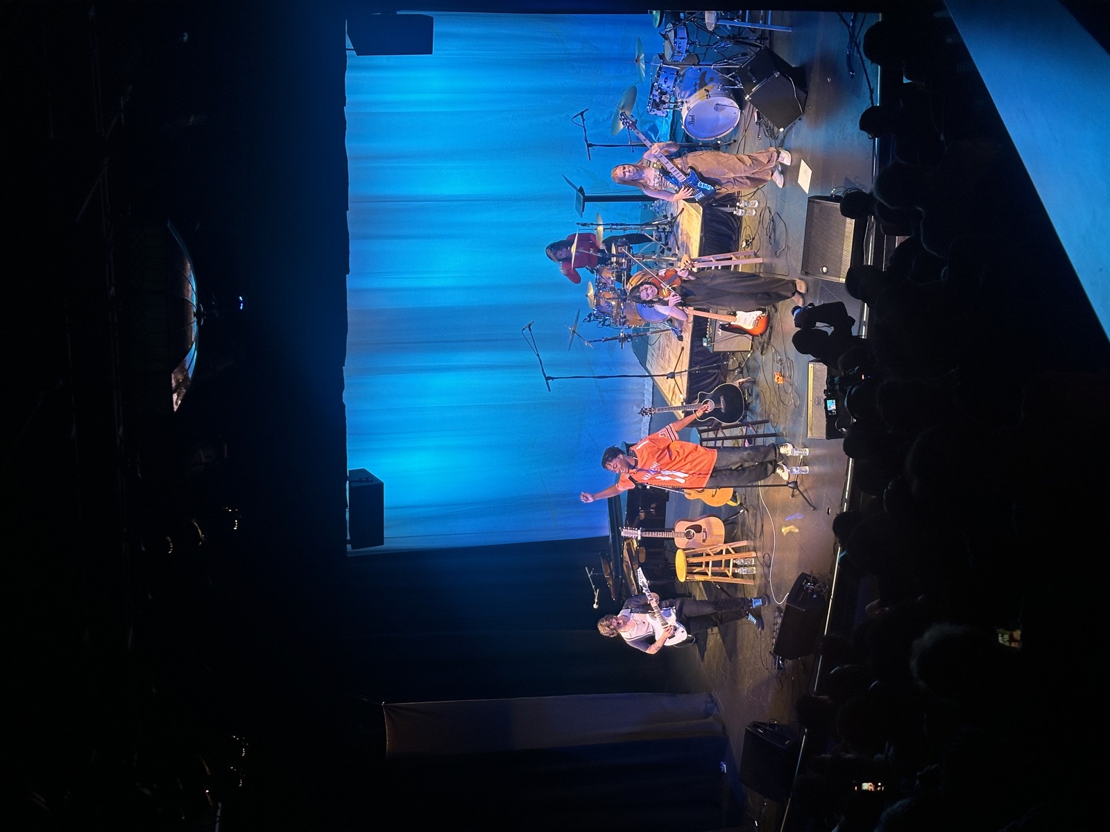 Live band on stage with blue curtain
