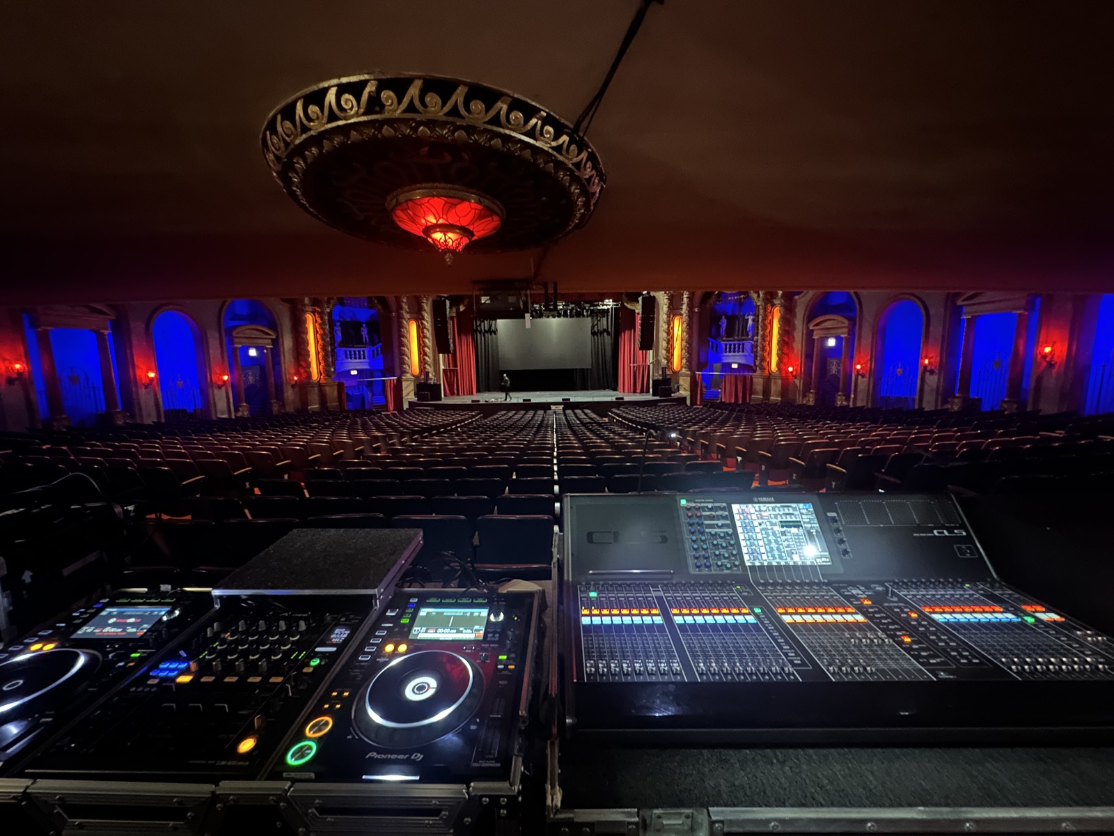 Front-of-house digital mixing console facing a lit stage